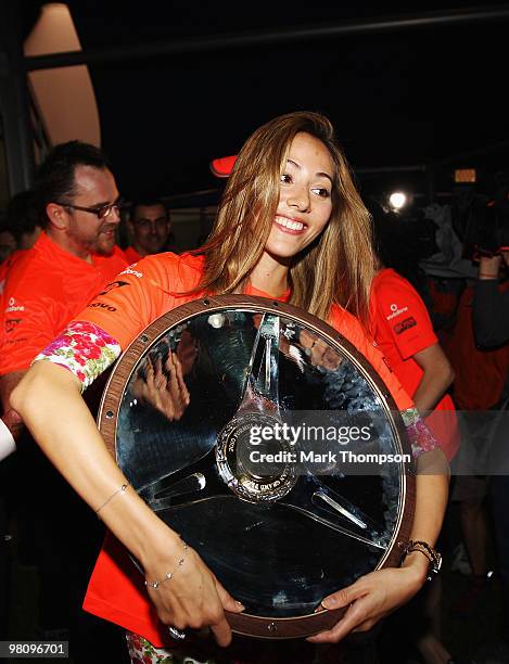 Jessica Michibata celebrates with the winners trophy of boyfriend Jenson Button of Great Britain and McLaren Mercedes in the paddock after he wins...