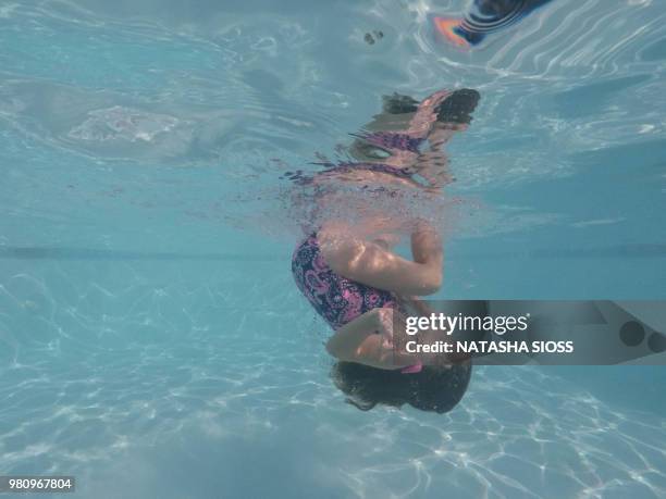 underwater photo of young girl in a swimsuit in a private pool - holding nose stock pictures, royalty-free photos & images