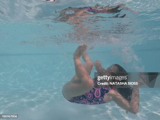 underwater photo of young girl in a swimsuit in a private pool - holding nose stock pictures, royalty-free photos & images