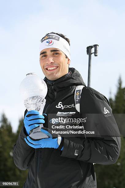 Martin Fourcade of France shows his olympic medal and his globe for the victory in the pursuit world cup during a special photo call during the E.On...