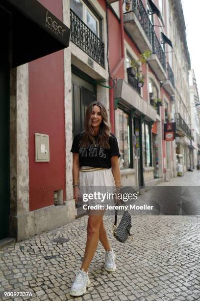 Janina Pfau wearing a YSL shirt, Chanel belt, Dior Saddle bag, Balenciaga Triple S shoes and a Chloe ring on June 18, 2018 in Lisbon, Portugal. .