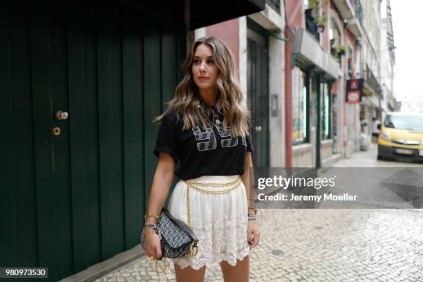 Janina Pfau wearing a YSL shirt, Chanel belt, Dior Saddle bag, Balenciaga Triple S shoes and a Chloe ring on June 18, 2018 in Lisbon, Portugal. .