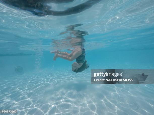 underwater photo of young girl in a swimsuit in a private pool - holding nose stock pictures, royalty-free photos & images