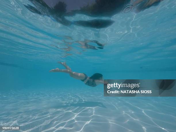 underwater photo of young girl in a swimsuit in a private pool - holding nose stock pictures, royalty-free photos & images