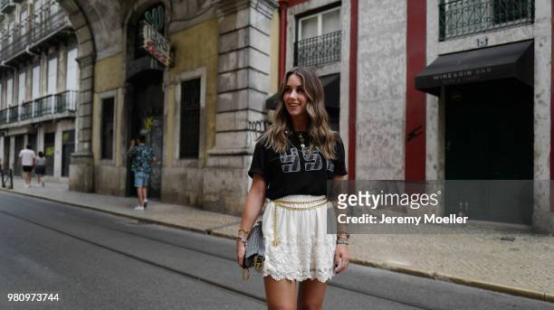 Janina Pfau wearing a YSL shirt, Chanel belt, Dior Saddle bag, Balenciaga Triple S shoes and a Chloe ring on June 18, 2018 in Lisbon, Portugal. .