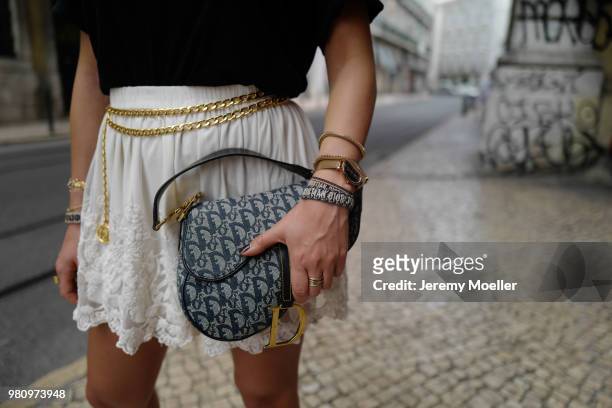 Janina Pfau wearing a YSL shirt, Chanel belt, Dior Saddle bag, Balenciaga Triple S shoes and a Chloe ring on June 18, 2018 in Lisbon, Portugal. .