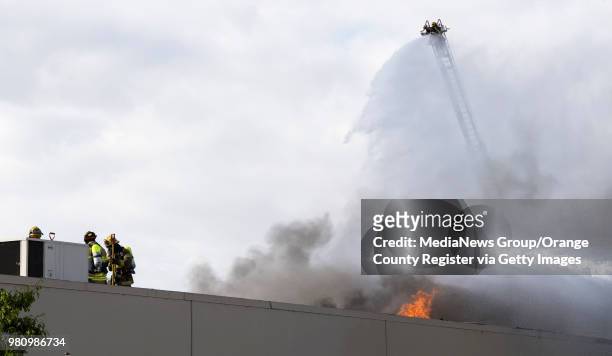 Firefighters from Anaheim, Fullerton, Brea, Orange, California and the Orange County Fire Authority battle a fire in a commercial building in the...