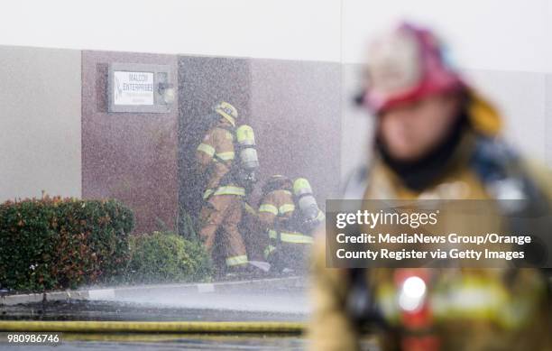 Firefighters enter a commercial business in the 1300 block of North Dynamics Street in Anaheim, California while fighting a fire on Monday, Feb. 12,...