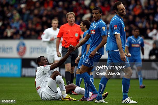 Luiz Gustavo of Hoffenheim helps up Mohamadou Idrissou of Freiburg during the Bundesliga match between 1899 Hoffenheim and SC Freiburg at the...