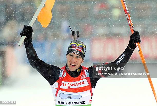 German Arnd Peiffer celebrates as he crosses the finish line to win the biathlon World Cup mixed relay in the Siberian city of Khanty-Mansiysk on...