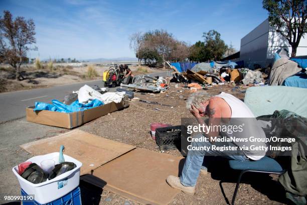Homeless man takes a break from clearing his belongings along the Santa Ana River Trail in Anaheim, California on Monday, Jan. 29, 2018. He expected...