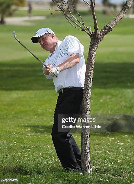 Richard Finch of England plays his second shot on the 12th hole as a small tree restricts his swing during the fourth round of the Open de Andalucia...