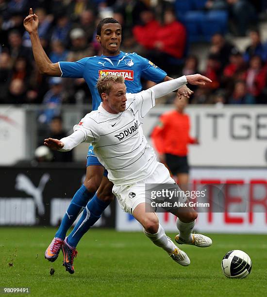 Felix Bastians of Freiburg is challenged by Luiz Gustavo of Hoffenheim during the Bundesliga match between 1899 Hoffenheim and SC Freiburg at the...