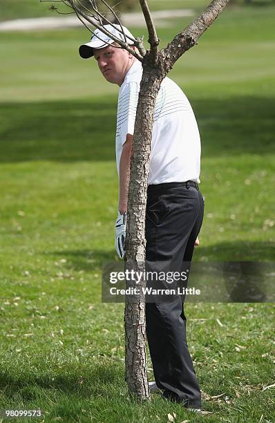 Richard Finch of England peers past a small tree to the green on the 12th hole during the fourth round of the Open de Andalucia 2010 at Parador de...