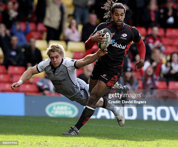 Noah Cato of Saracens breaks away from Charlie Amesbury to score a try during the Guinness Premiership match between Saracens and Newcastle Falcons...