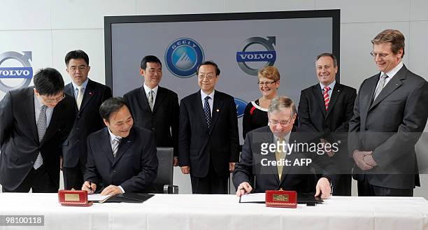 Chairman of Zhejiang Geely Holding Group Company Ltd Li Shufu and Lewis Booth , CFO Ford Motor Company, sign the stock purchase agreement at the...