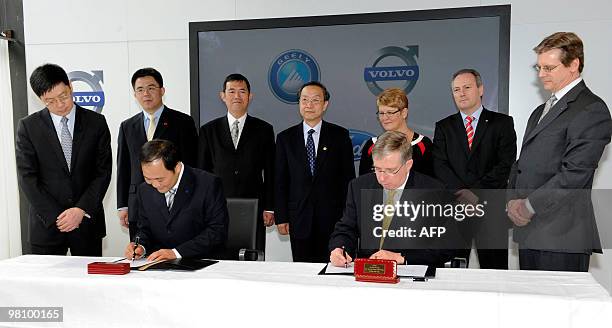 Chairman of Zhejiang Geely Holding Group Company Ltd Li Shufu and Lewis Booth , CFO Ford Motor Company, sign the stock purchase agreement at the...