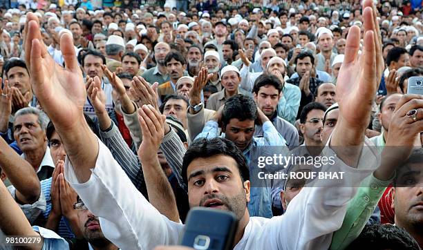 Kashmiri Muslim men praying at a shrine to Saint Syed Abdul Qadir Jilani react as an imam shows a believed relic of the Sufi saint on the anniversary...