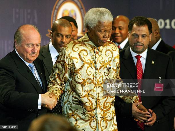 Former South African President Nelson Mandela is helped by FIFA President Joseph Blatter and the head of the South African bid committee Danny...