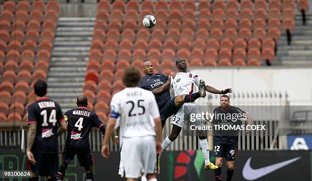 Paris' defender Sammy Traore heads a ball next to Boulogne's forward Mustapha Yatabare during the French L1 football match Paris SG vs...