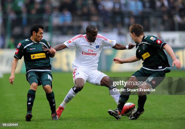 Guy Demel of Hamburg is challenged by Thorben Marx and Juan Arango of Gladbach during the Bundesliga match between Borussia Moenchengladbach and...