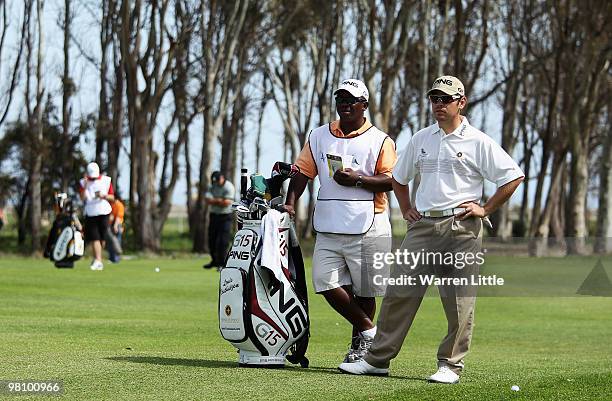 Louis Oosthuizen of South Africa prepares to play his second shot into the 12th green as he speaks with his caddie Zack during the fourth round of...