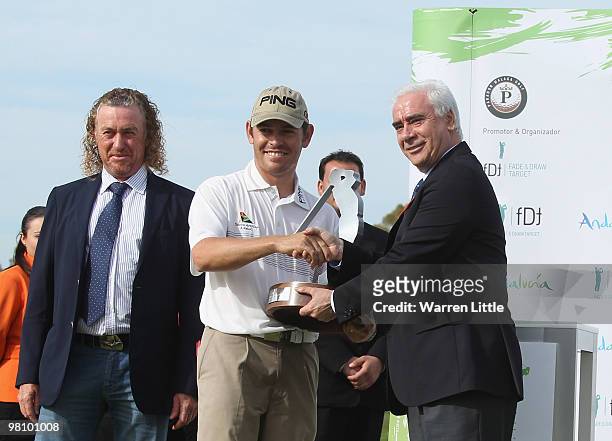 Louis Oosthuizen of South Africa is awarded the trophy by Luciano Alonso, Minister of Tourism, Trade and Sports for Junta de Andalucia after winning...