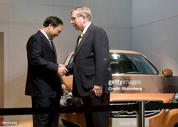 Li Shufu, chairman of Zhejiang Geely Holding Co., left, and Lewis Booth, chief financial officer at Ford Motor Co., shake hands before a Volvo S60...