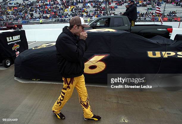 David Ragan tries to warm up as he stands by his car on pit lane during a rain delay before the start of the NASCAR Sprint Cup Series Goody's Fast...