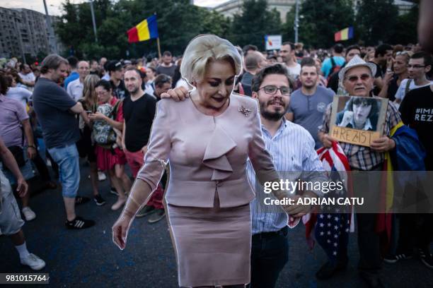 Demonstrator holds a full-size cardboard cut-out depicting Romania's Prime Minister Viorica Dancila during a gathering in front of the Romanian Prime...