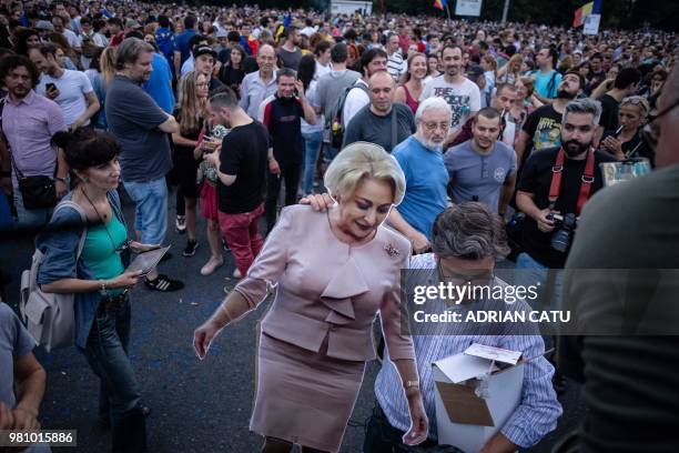 Demonstrator holds a full-size cardboard cut-out depicting Romania's Prime Minister Viorica Dancila during a gathering in front of the Romanian Prime...