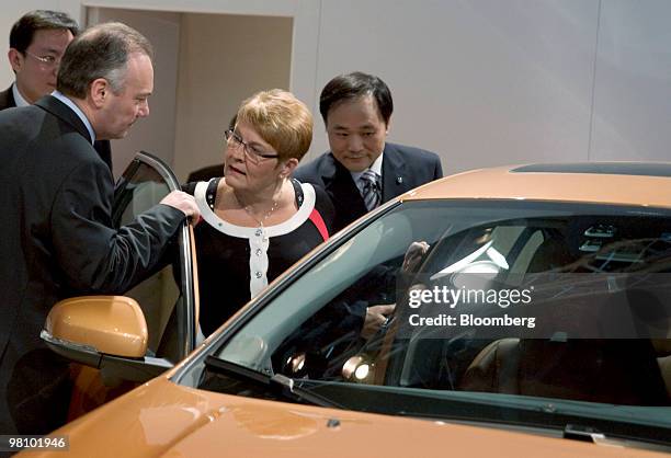 Stephen Odell, chief executive officer of Volvo Cars, left, and Li Shufu, chairman of Zhejiang Geely Holding Co., right, show Maud Olofsson, Sweden's...