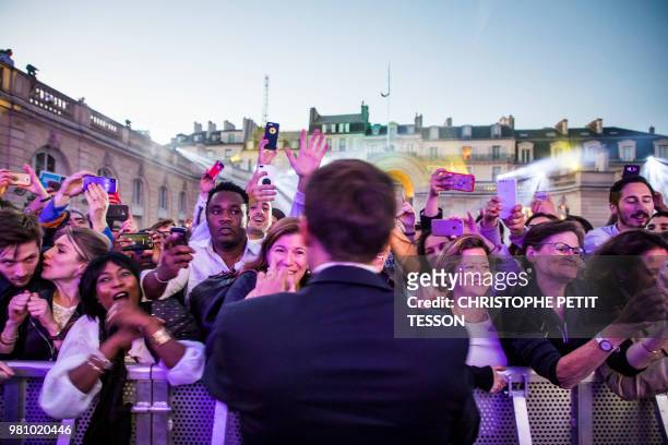 French president Emmanuel Macron shakes hands during the 'Fete de la Musique', the music day celebration in the courtyard of the Elysee Palace, in...