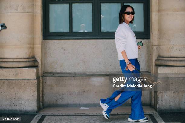 Aimee Song at Louis Vuitton in a LV white top, blue pants, Archlight sneakers, and purse during Paris Fashion Week Mens Spring/Summer 2019 on June...