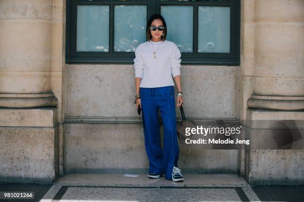 Aimee Song at Louis Vuitton in a LV white top, blue pants, Archlight sneakers, and purse during Paris Fashion Week Mens Spring/Summer 2019 on June...