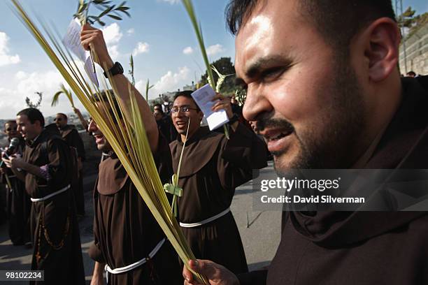Spanish Catholic clergy carry palm and olive leaves as they walk down the Mount of Olives to the Old City during the traditional Palm Sunday...