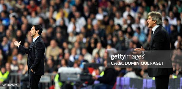 Atletico Madrid's coach Quique Sanchez Flores and Real Madri'd coach Manuel Pellegrini react during the Spanish league football match Real Madrid...