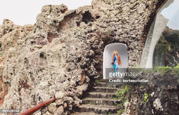 woman walking in archway of old ruin - bortes stock-fotos und bilder