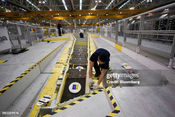 An employee works on an wing in a jig on the Airbus A350 wing production line at the Airbus SE assembly factory in Broughton, U.K., on Monday, Jan....