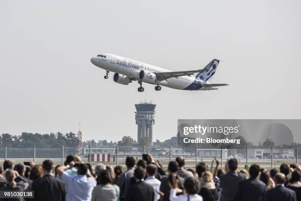 Spectators watch as an Airbus A320neo aircraft manufactured by Airbus Group NV takes off on its debut flight at Toulouse-Blagnac airport in Toulouse,...