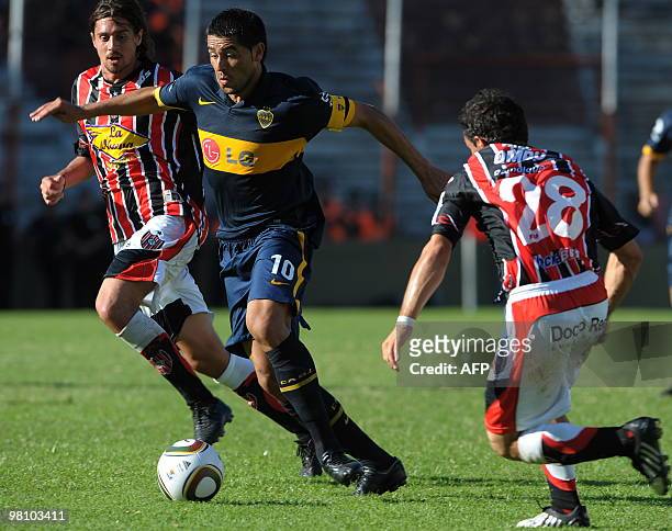 Boca Juniors' midfielder Juan Roman Riquelme controls the ball between midfielder Federico Vismara and midfielder Omar Zarif of Chacarita during...