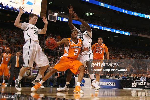 Bobby Maze of the Tennessee Volunteers looks to shoot the ball against Mike Kebler and Draymond Green both of the Michigan State Spartans during the...