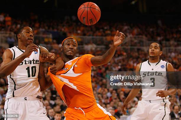 Delvon Roe of the Michigan State Spartans defends against Wayne Chism of the Tennessee Volunteers during the midwest regional final of the 2010 NCAA...