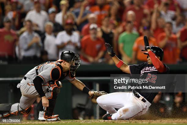 Juan Soto of the Washington Nationals is safe at home plate as he avoids the tag of Caleb Joseph of the Baltimore Orioles in the seventh inning at...
