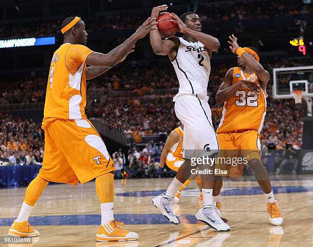 Raymar Morgan of the Michigan State Spartans tries to get around Wayne Chism and Scotty Hopson of the Tennessee Volunteers during the midwest...