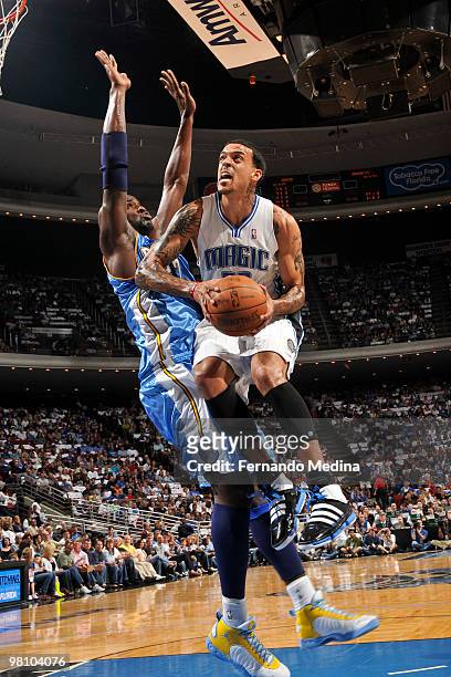 Matt Barnes of the Orlando Magic shoots against Johan Petro of the Denver Nuggets during the game on March 28, 2010 at Amway Arena in Orlando,...