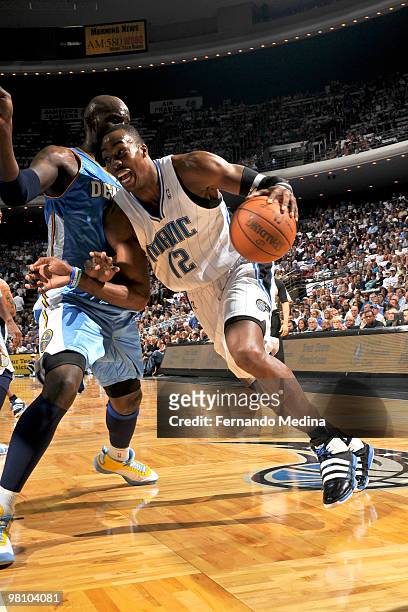 Dwight Howard of the Orlando Magic drives against Johan Petro of the Denver Nuggets during the game on March 28, 2010 at Amway Arena in Orlando,...