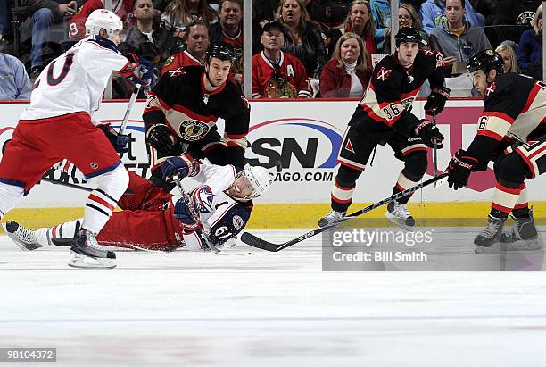 Rick Nash of the Columbus Blue Jackets falls to the ice in front of Brent Seabrook of the Chicago Blackhawks, as Andrew Ladd and Dave Bolland of the...