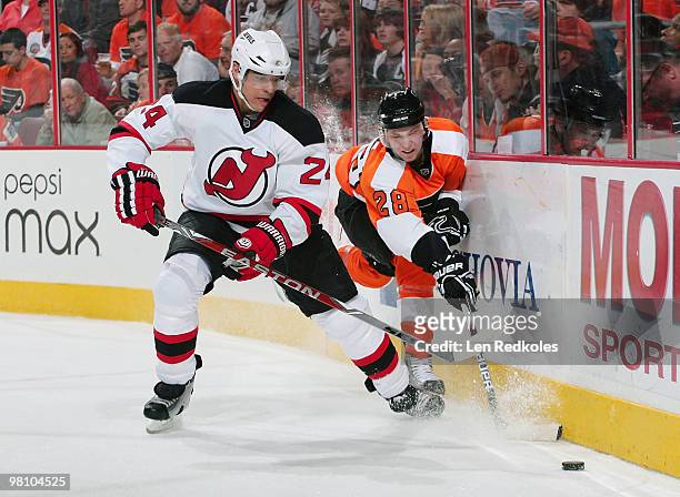 Claude Giroux of the Philadelphia Flyers battles for the loose puck behind the net with Bryce Salvador of the New Jersey Devils on March 28, 2010 at...