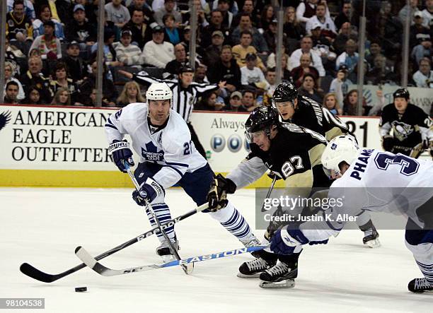 Sidney Crosby of the Pittsburgh Penguins handles the puck through the checks of Dion Phaneuf and Francois Beauchemin of the Toronto Maple Leafs in...